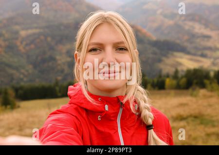 Happy young woman taking selfie in mountains Stock Photo