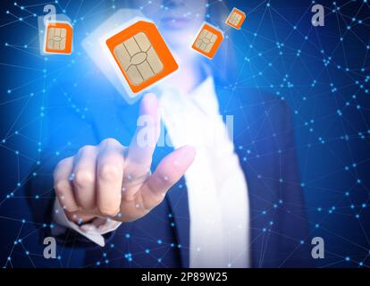 Woman demonstrating SIM cards of different sizes on color background, closeup Stock Photo