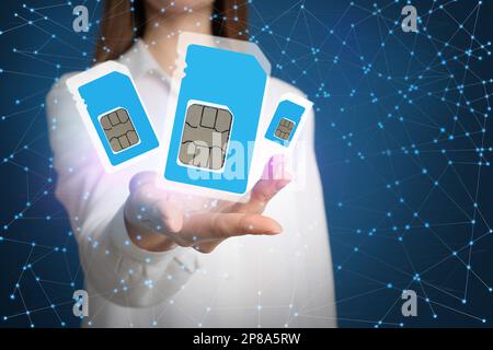 Woman demonstrating SIM cards of different sizes on color background, closeup Stock Photo