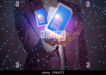 Woman demonstrating SIM cards of different sizes on color background, closeup Stock Photo