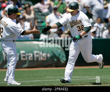 Oakland Athletics' Jason Giambi, right, is congratulated by coach