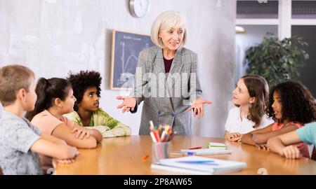 Mature female teacher conducts a lesson in a classroom Stock Photo - Alamy