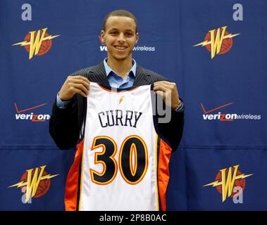 Golden State Warriors top draft pick Stephen Curry poses with his new  jersey during a news conference at the Warriors headquarters in Oakland,  Calif., Friday, June 26, 2009. Curry, a guard from