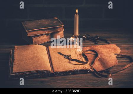 Old antique books with candle on wooden background Stock Photo