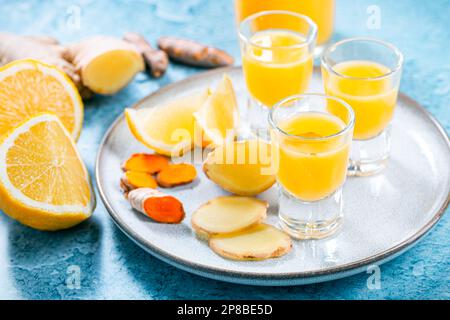 Boosting immune system - homemade healthy Ginger Lemon Turmeric Shot with ingredients Stock Photo