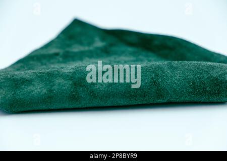 Piece of green leather and suede cut on white background. Concept and idea of fine leather crafting, handmade, handcrafted and leather works. Backgrou Stock Photo