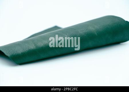 Piece of green leather and suede cut on white background. Concept and idea of fine leather crafting, handmade, handcrafted and leather works. Backgrou Stock Photo