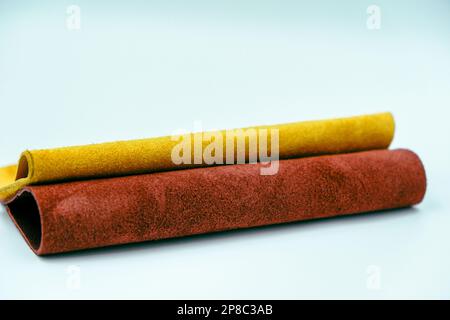 Rolls of natural colorful leather. Materials for leather craft. Red and yellow suede Stock Photo