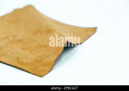 Genuine leather piece isolated on white background. Brown genuine leather roll. Real leather surface. Hobby and craft material. Manufacture, backgroun Stock Photo