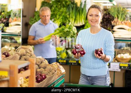 woman buy large onion in supermarket Stock Photo