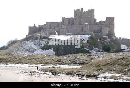 General view of Bamburgh Castle surrounded by snow in Bamburgh, Northumberland. Picture date: Thursday March 9, 2023. Stock Photo