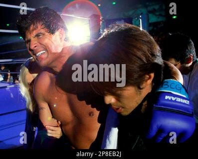 Former major league MVP player Jose Canseco, left, and former Seattle  Mariners closer Kazuhiro Sasaki, both wearing Yokohama BayStars jerseys,  react after attending the first-pitch ceremony for a Japanese professional  baseball game