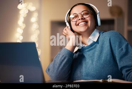 Student, music headphones and woman in home at night streaming radio or podcast after elearning. Freelancer, remote worker or happy business female Stock Photo