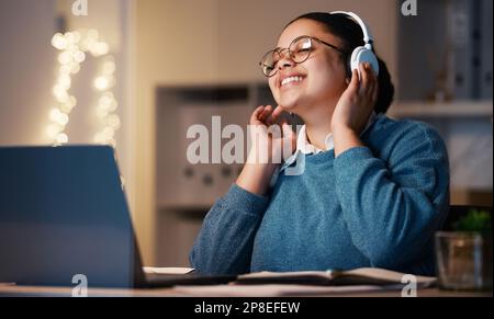 Music headphones, student and woman in home at night streaming radio or podcast after elearning. Freelancer, remote worker or happy business female Stock Photo