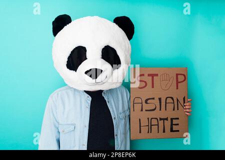 Funny man holding a poster against asian racism - Stop asian hate campaign concept Stock Photo