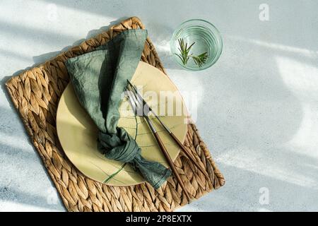 Close-up overhead view of a rustic place setting with glass of rosemary water Stock Photo