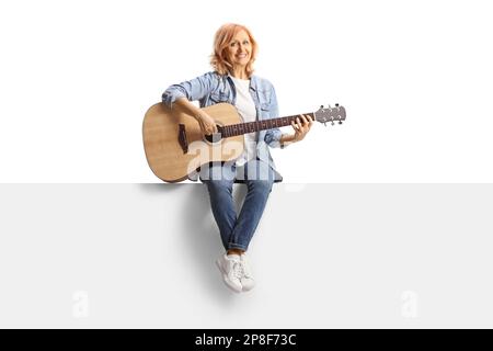 Woman sitting on a panel with an acoustic guitar isolated on white ...