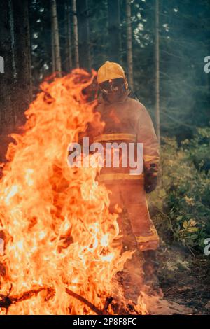 Firefighter at job. Firefighter in dangerous forest areas surrounded by strong fire. Concept of the work of the fire service Stock Photo