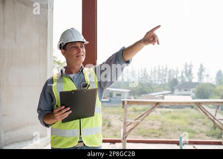 Young engineering with paperwork on the inspecting the reconstructed construction and renovation after to check defect of building at site. Stock Photo