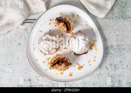 Freshly baked cream puffs. Eclair cake with cream and chocolate filling. Top view Stock Photo
