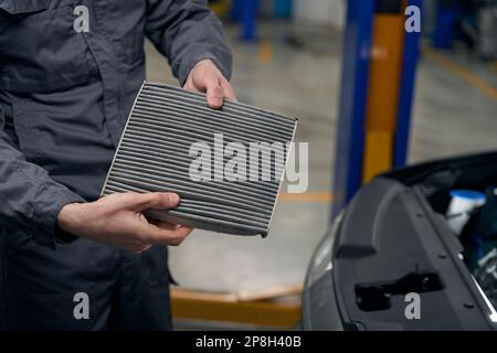 Worker changing spare parts in the car Stock Photo