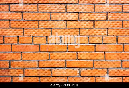Red brick wall as creative background. Bricks masonry with seams Stock Photo