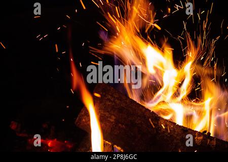 Sparks fly from a burning wood fire Stock Photo
