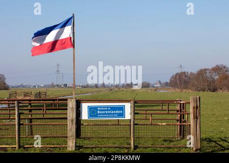 Rotterdam, The Netherlands – March 2nd, 2023: Dutch flag upside down because of farmer protest in the Netherlands and a sign that this farmland is ind Stock Photo
