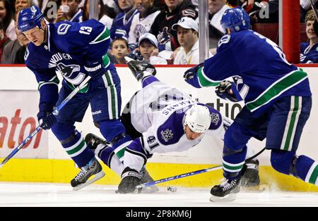 Vancouver Canucks' Mats Sundin, left, of Sweden, falls to his knees after  being checked by New Jersey Devils' Brian Rolston during the first period  of an NHL hockey game in Vancouver, British