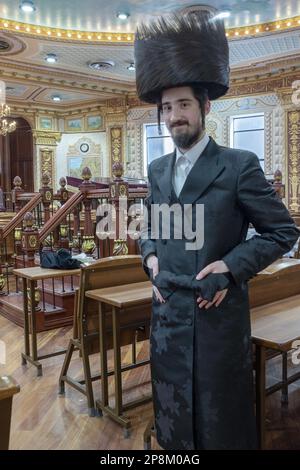 Posed portrait of a hasidic man wearing a shtreimel fur hat in an empty synagogue on Purim. In Brooklyn NY, 2023. Stock Photo