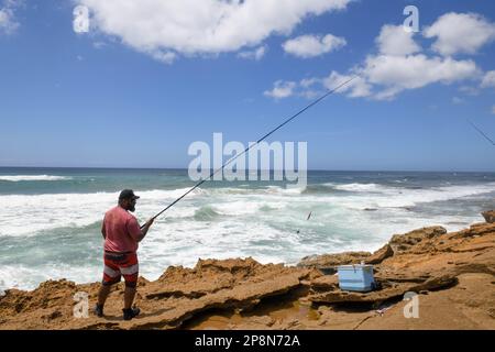 Mission Rocks, South Africa - 14 January 2023: people fishing at Mission Rocks on Isimangaliso park in South Africa Stock Photo