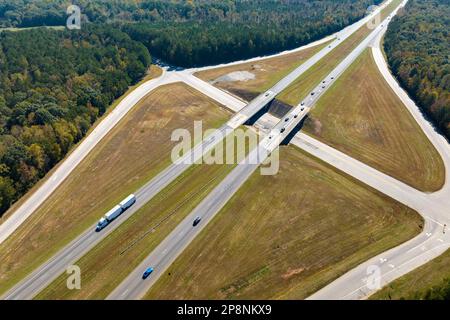View from above of busy american highway with fast moving traffic between woods. Interstate transportation concept. Stock Photo