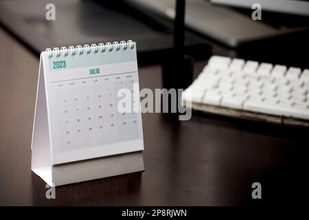 July 2023 calendar with on student desk wooden brown table Stock Photo