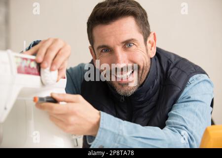 mechanic repairing sewing machine with screwdriver Stock Photo