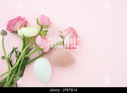 Easter eggs and Buttercups flower bouquet on pastel pink background, copy space. Happy Easter Stock Photo