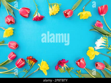 Spring flowers frame on blue background, copy space. Happy Easter, Woman, Mother day card template Stock Photo