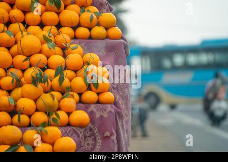 oranges kinnu citrus fruit piled up at a roadside stall showing how farmers traditionally sell this local fruit in India for eating and juice as a Stock Photo