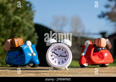 Toy scooters and alarm clock. Travel time. Fast concept delivery Stock Photo
