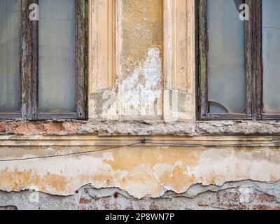 Detail with an old worn out building. Plaster peeling from an old brick wall in Bucharest, Romania. Stock Photo