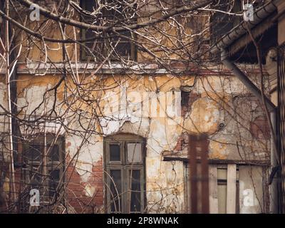Detail with an old worn out building. Plaster peeling from an old brick wall in Bucharest, Romania. Stock Photo
