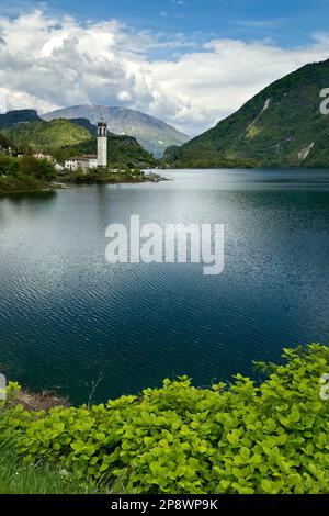 The lake of Corlo and the bell tower of the village of Rocca. Arsié, Belluno province, Veneto, Italy. Stock Photo