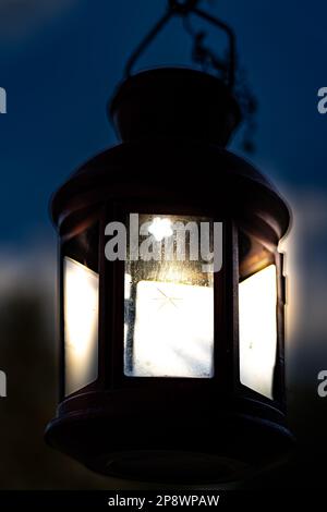 Little lantern with glass and a blurred background with lights on at night Stock Photo