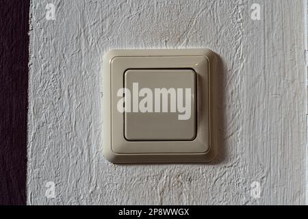 Light switch on the white wall to turn on the light Stock Photo
