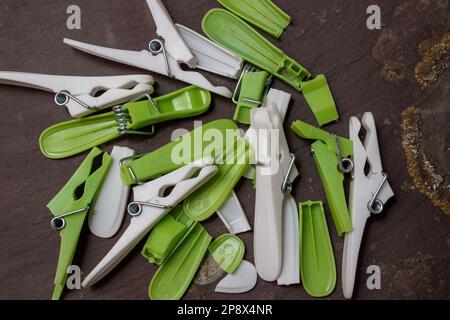Broken cheap plastic clothes pegs on a piece of grey slate Stock Photo