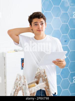 Confused young designer determining scope of work in apartment during refurbishment Stock Photo