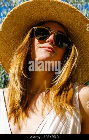 A close up of beautiful woman wearing sunglasses and a sun hat on a sunny day in California. Stock Photo