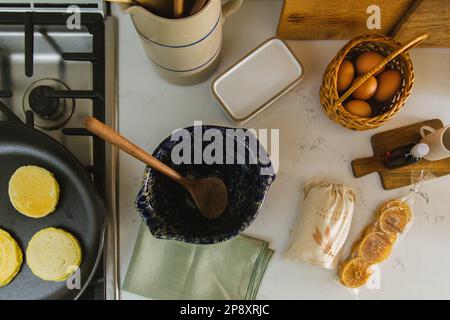 An overhead image of pancakes being made and ingredients on the kitchen counter Stock Photo