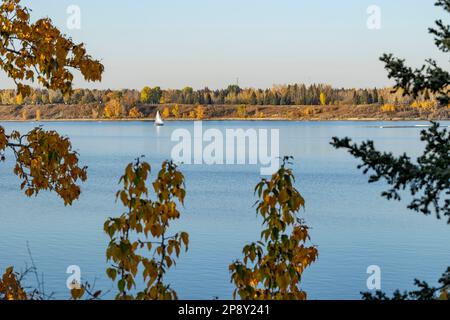 Calgary, Alberta, Canada - Sailboat on Glenmore Reservoir as viewed from South Glenmore Park, on an autumn evening Stock Photo