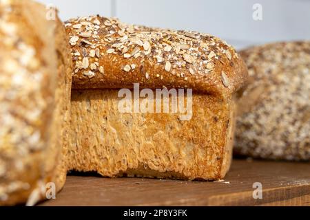 Fresh-baked loaves of bread on a shelf in a bakery Stock Photo