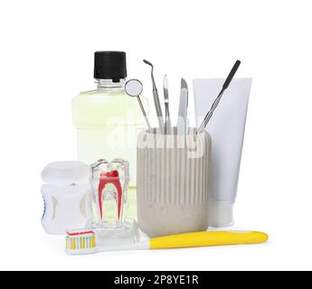 Tooth model, oral hygiene products and dentist tools on white background Stock Photo